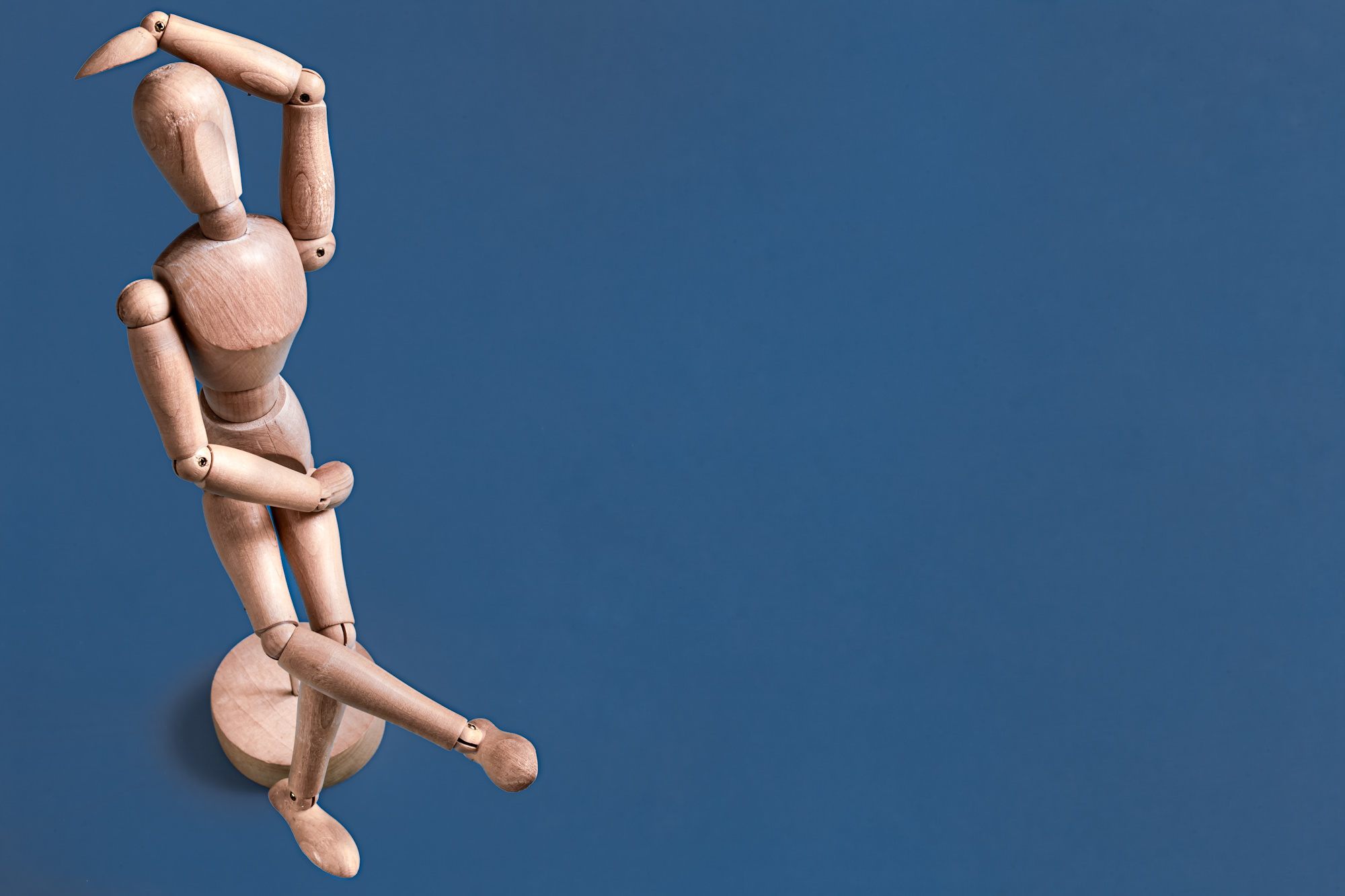 The wooden man figurine on a blue background . Concept of objects .